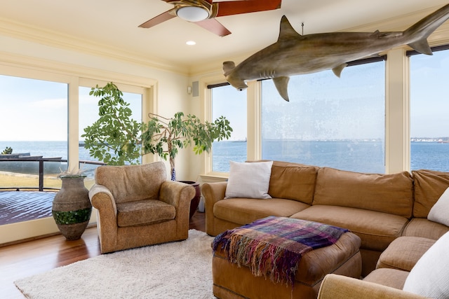 sunroom / solarium with a water view, ceiling fan, and plenty of natural light