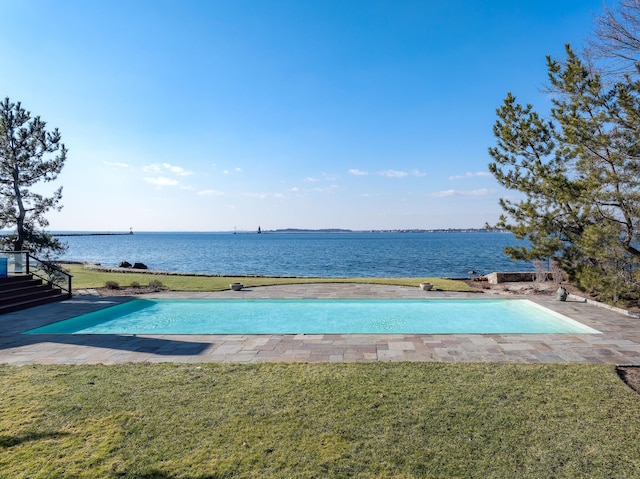 view of swimming pool featuring a water view and a yard