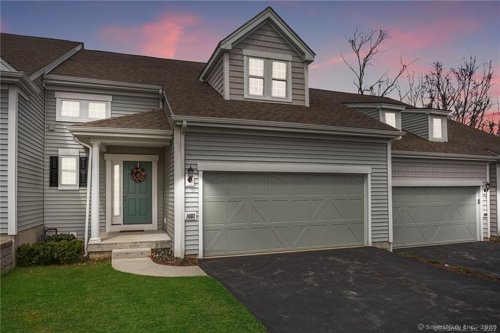 new england style home with a yard and a garage