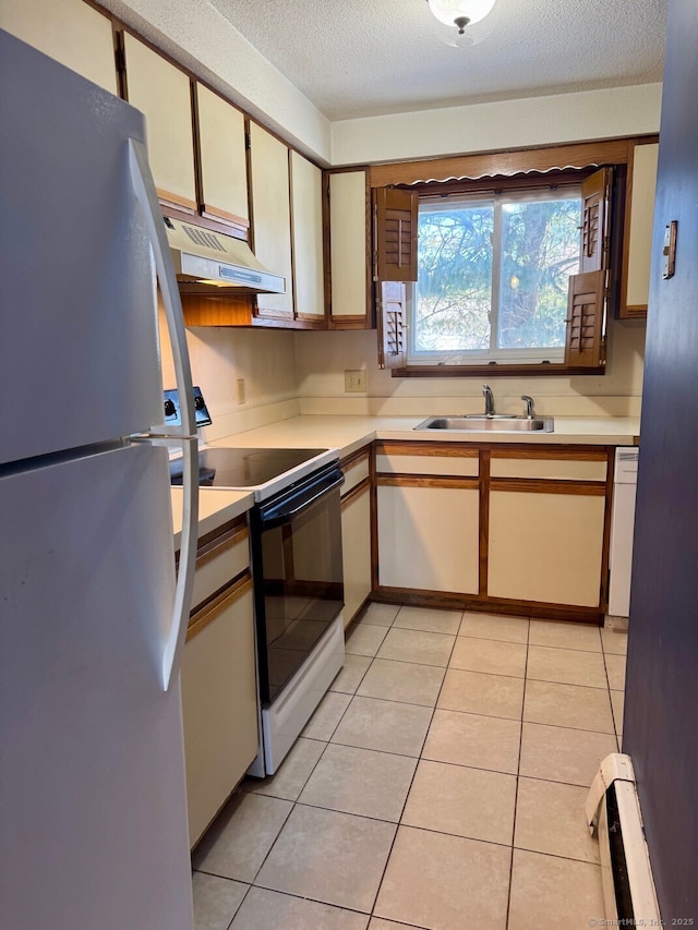 kitchen featuring exhaust hood, a textured ceiling, range with electric cooktop, sink, and white refrigerator