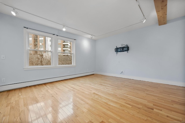 unfurnished room featuring beam ceiling, a baseboard heating unit, light hardwood / wood-style flooring, and track lighting