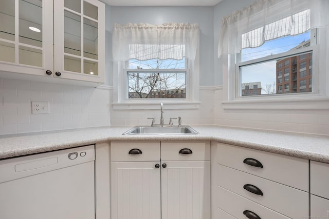 kitchen featuring white cabinets, backsplash, sink, and white dishwasher