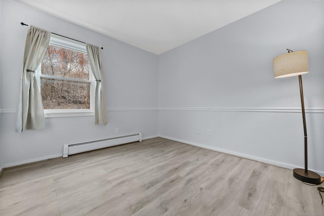 spare room featuring light wood-type flooring and baseboard heating