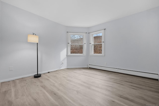 empty room with a baseboard heating unit and light wood-type flooring