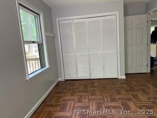 unfurnished bedroom with dark parquet flooring