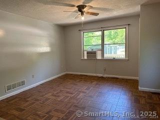 empty room with ceiling fan and dark parquet floors