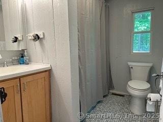 bathroom with toilet, tile patterned flooring, and vanity