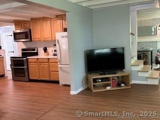 kitchen with beamed ceiling, dark hardwood / wood-style floors, and stainless steel appliances