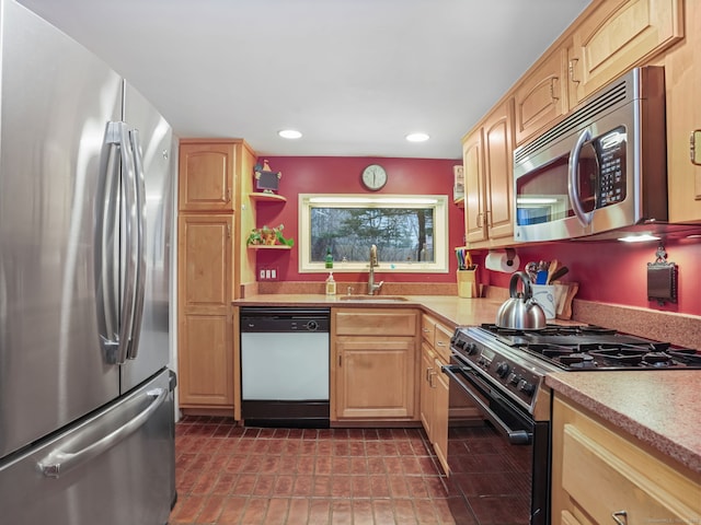 kitchen featuring appliances with stainless steel finishes, light brown cabinetry, and sink