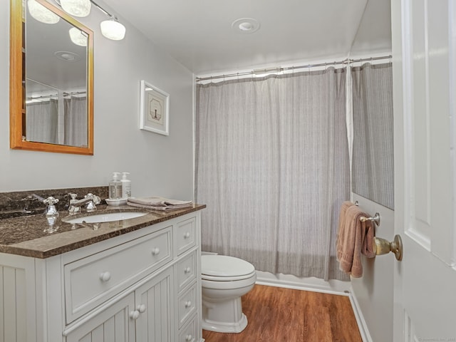 full bathroom with vanity, hardwood / wood-style floors, shower / bath combination with curtain, and toilet