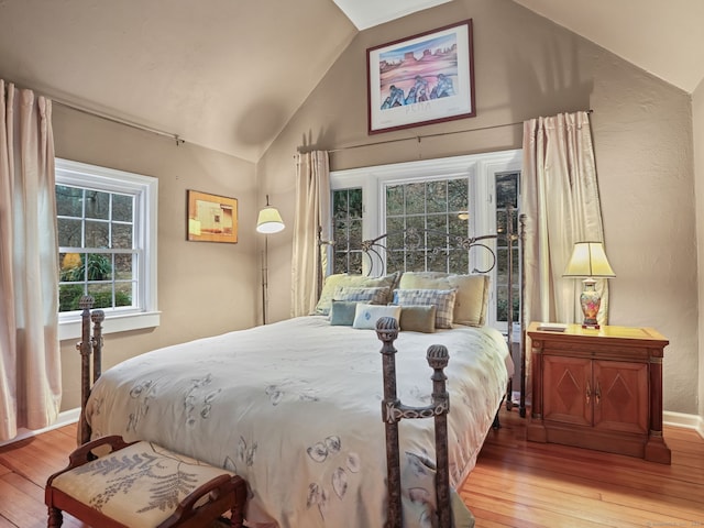 bedroom featuring lofted ceiling and light wood-type flooring