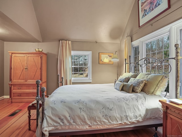 bedroom with lofted ceiling, access to exterior, and light hardwood / wood-style flooring