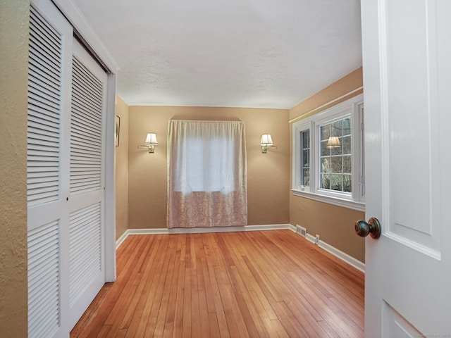 unfurnished bedroom with light hardwood / wood-style floors and a closet