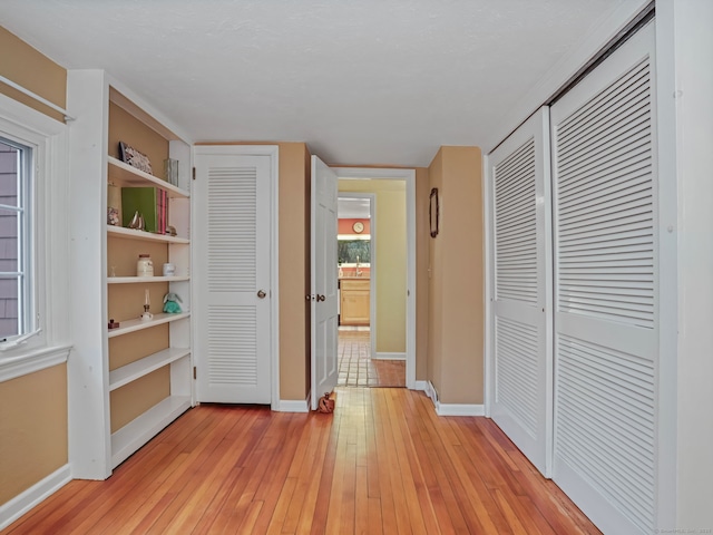 unfurnished bedroom featuring multiple closets and light hardwood / wood-style flooring