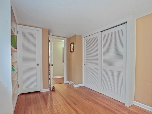 unfurnished bedroom featuring a closet and light wood-type flooring