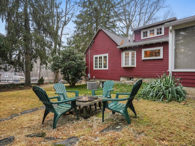 exterior space with an outdoor fire pit and central AC unit