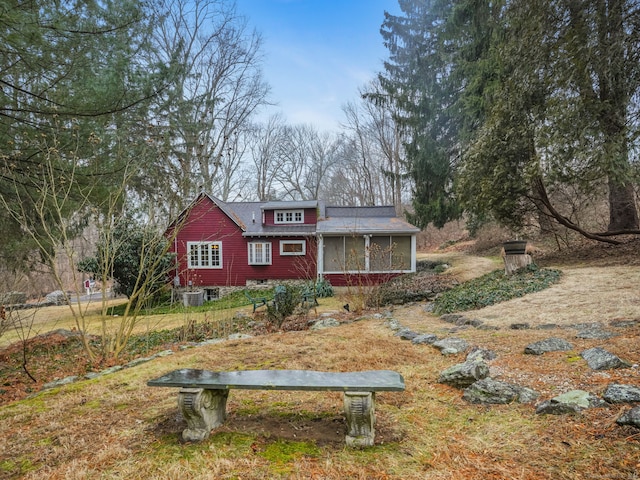 view of front of property with a front yard and a sunroom