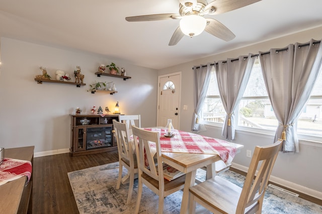 dining area with dark wood-type flooring and ceiling fan