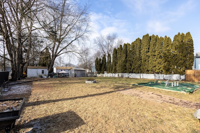 view of yard with a shed and a fire pit