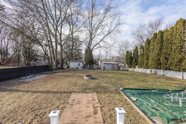 view of yard with a fire pit and a storage unit