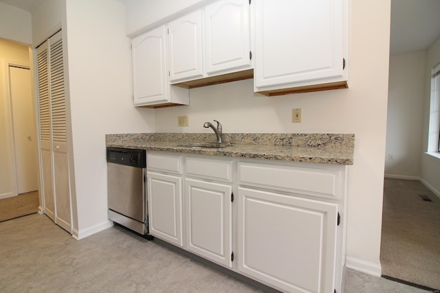 kitchen with white cabinets, dishwasher, sink, and light stone counters