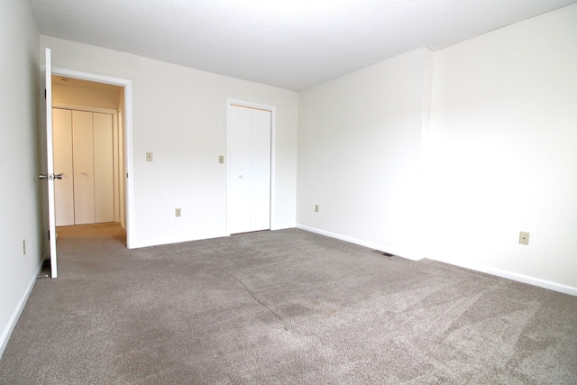 unfurnished bedroom with dark colored carpet