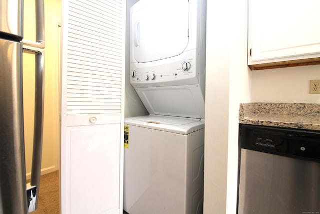 laundry area featuring stacked washer / drying machine and carpet flooring