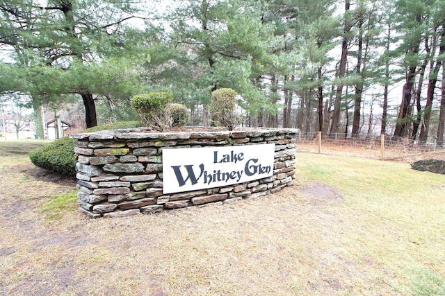 community / neighborhood sign featuring a lawn