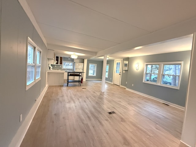 unfurnished living room with a healthy amount of sunlight and light hardwood / wood-style flooring