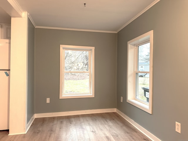 unfurnished dining area featuring ornamental molding and light hardwood / wood-style flooring