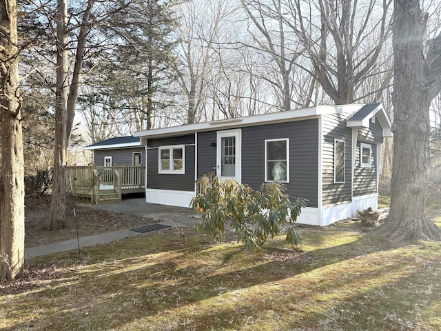 view of front of house with a front yard and a deck