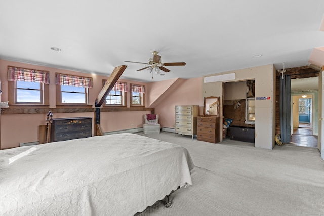 bedroom with ceiling fan, a baseboard heating unit, and light carpet