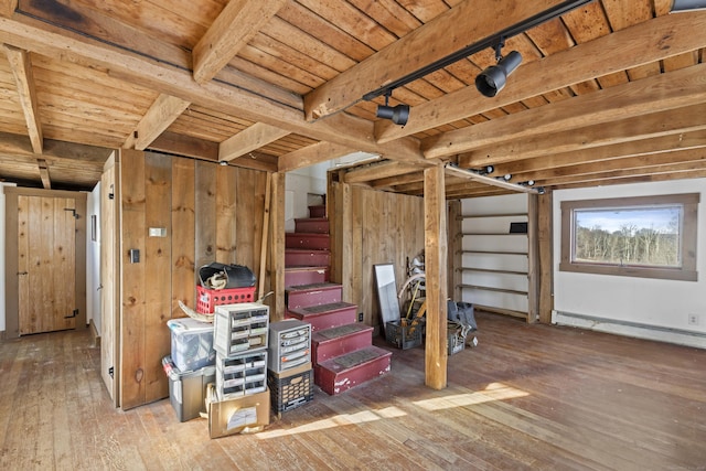 basement featuring hardwood / wood-style flooring, baseboard heating, wood walls, and wood ceiling