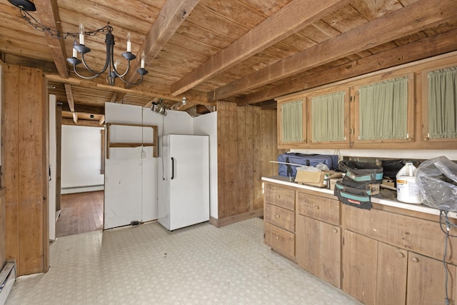 kitchen with a baseboard radiator, beam ceiling, white fridge, and wooden walls