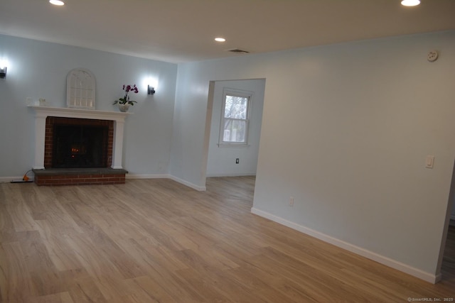 unfurnished living room with recessed lighting, a fireplace, visible vents, and light wood-type flooring