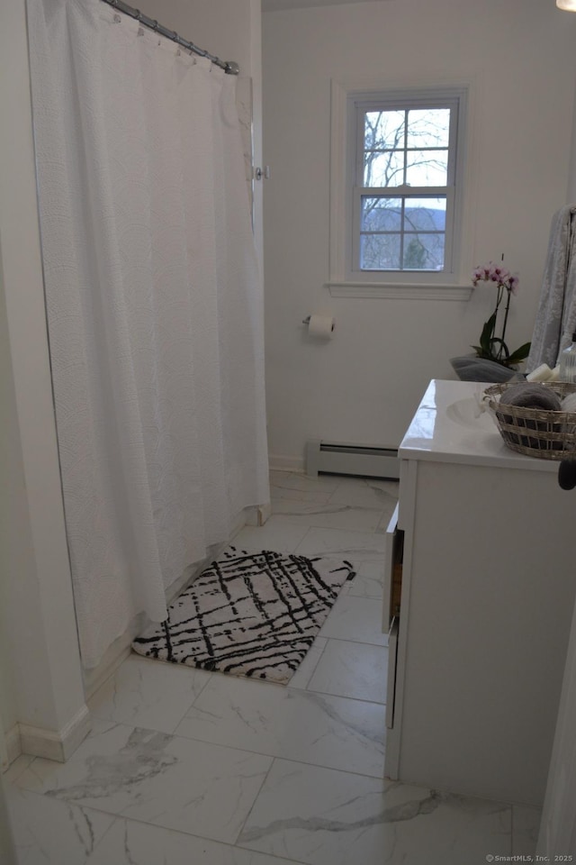 bathroom featuring baseboard heating and vanity