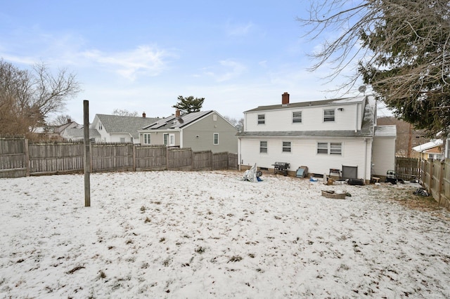 view of snow covered rear of property