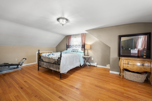 bedroom featuring baseboard heating, lofted ceiling, and light hardwood / wood-style flooring