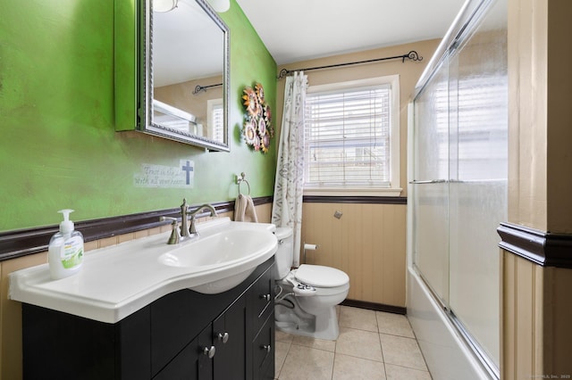 full bathroom featuring tile patterned flooring, vanity, toilet, and bath / shower combo with glass door