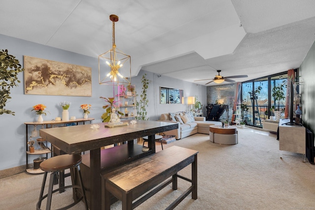 dining area featuring light carpet, a wall of windows, and ceiling fan with notable chandelier