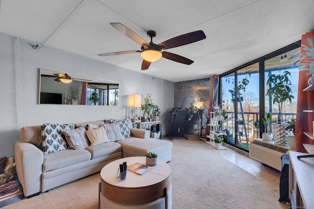 living room with ceiling fan, a textured ceiling, and a wall of windows