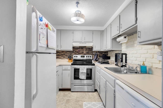 kitchen featuring sink, white appliances, a textured ceiling, and tasteful backsplash