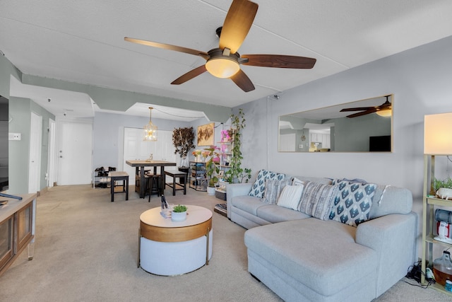 carpeted living room with ceiling fan