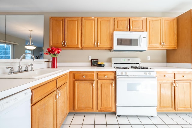 kitchen featuring sink, white appliances, decorative light fixtures, and light tile patterned floors