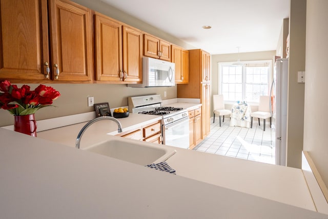 kitchen featuring light tile patterned flooring, sink, and white appliances