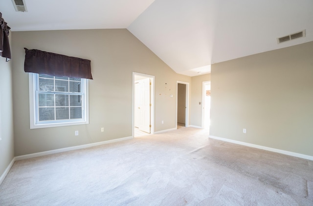 carpeted empty room featuring high vaulted ceiling