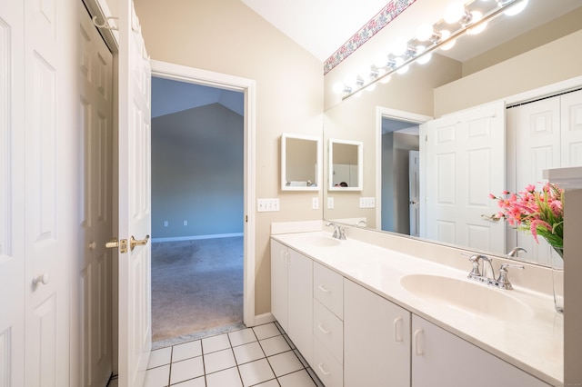 bathroom with vanity, lofted ceiling, and tile patterned floors