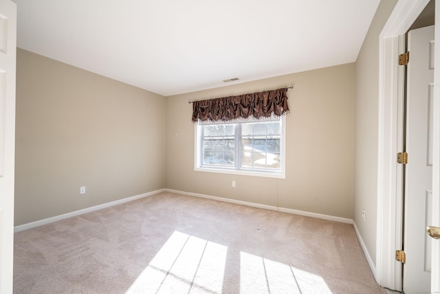 unfurnished room featuring light carpet