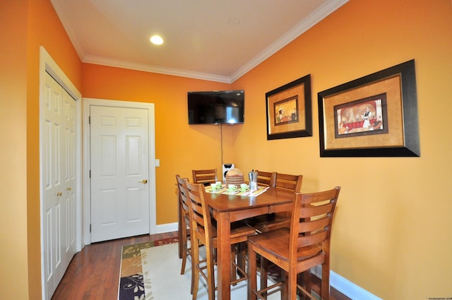 dining space featuring dark wood-type flooring and crown molding