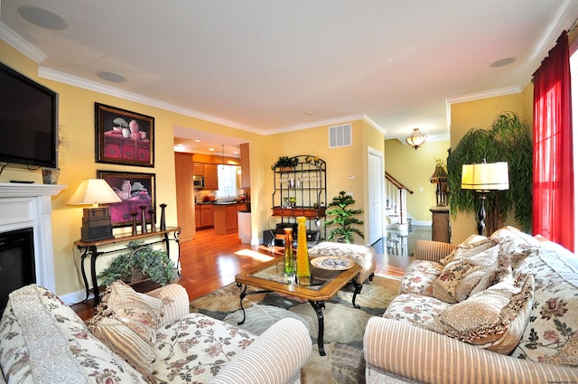 living room with ornamental molding and light hardwood / wood-style floors